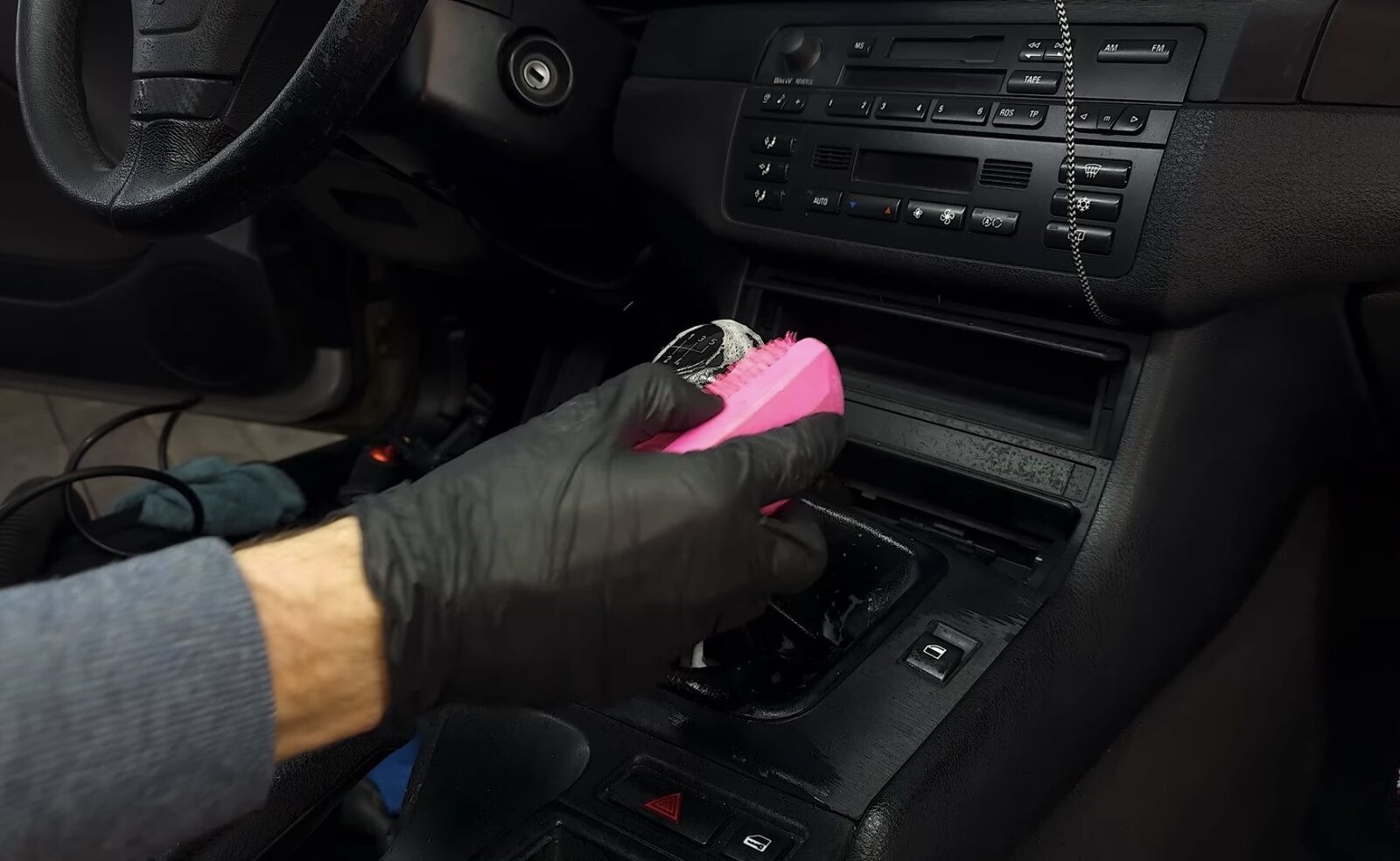 Brossage de la console centrale et de l'autoradio avec produit nettoyant